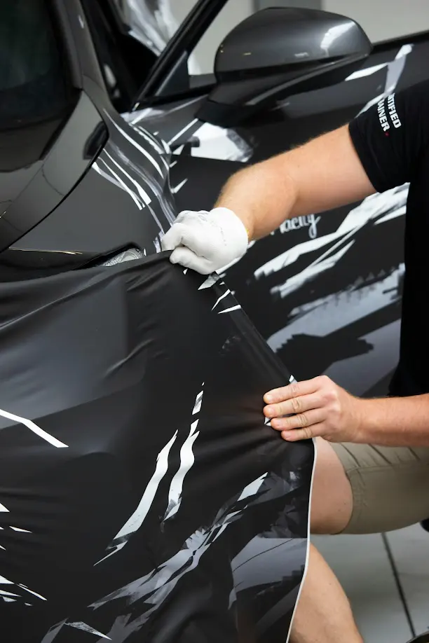 Colored Paint Protection Film being applied to a vehicle showcasing a PPF service offered by Wrap Daddy's