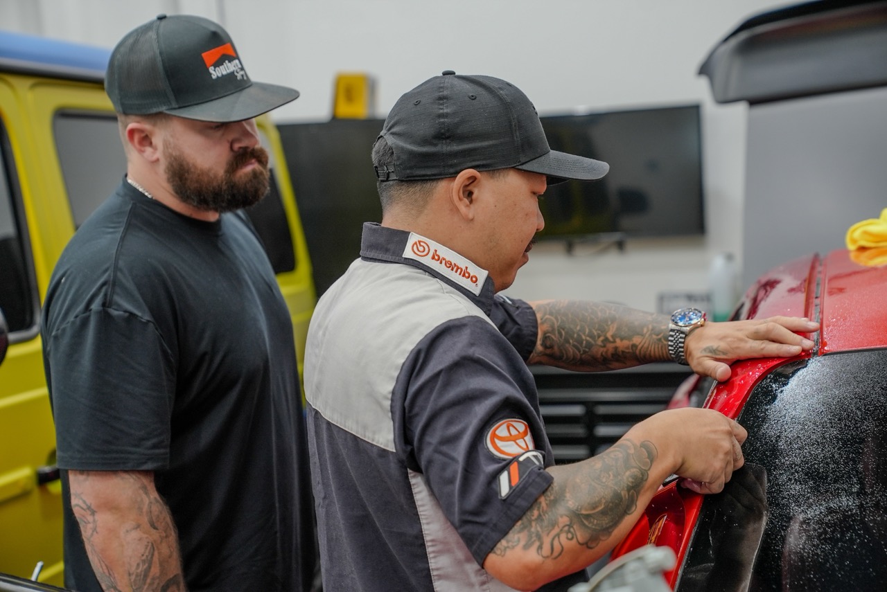 An instructor demonstrating how to install vinyl onto a vehicle